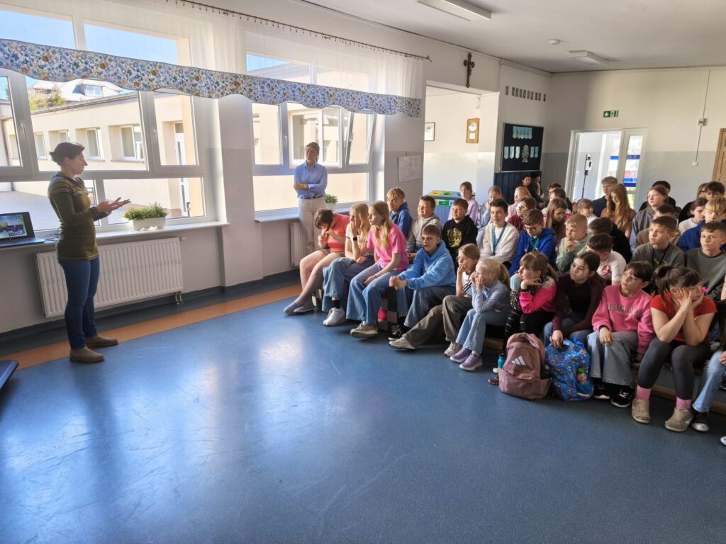 Uczniowie słuchają prelekcji o ekologii i dbaniu o planetę podczas szkolnych zajęć.