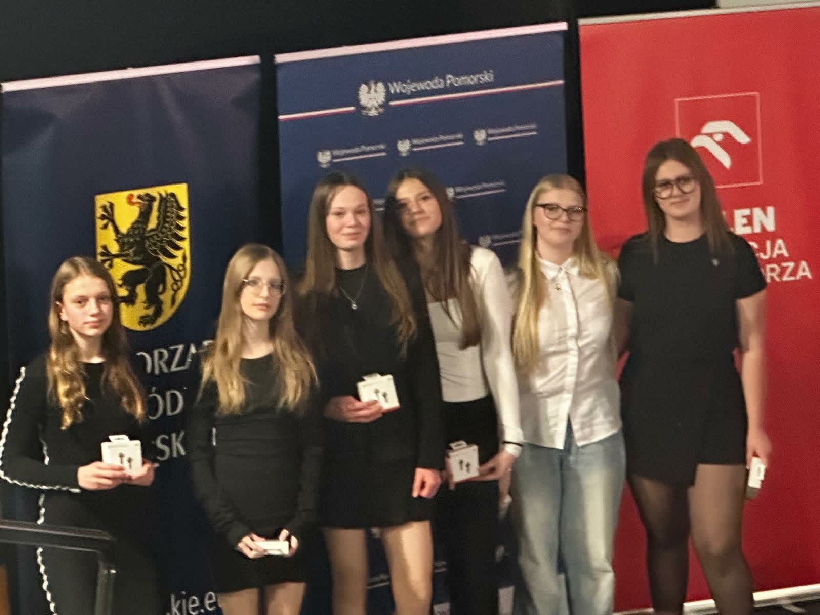 Uczennice prezentują nagrody podczas gali finałowej projektu edukacyjnego.