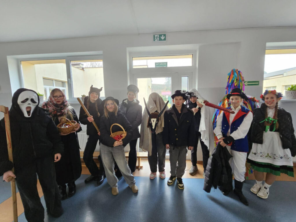 Grupa uczniów przebranych za tradycyjnych kolędników, m.in. śmierć, diabła i bociana.