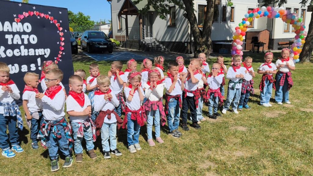 Dzieci prezentują program artystyczny z okazji Dnia Mamy i Taty na szkolnym festynie rodzinnym.